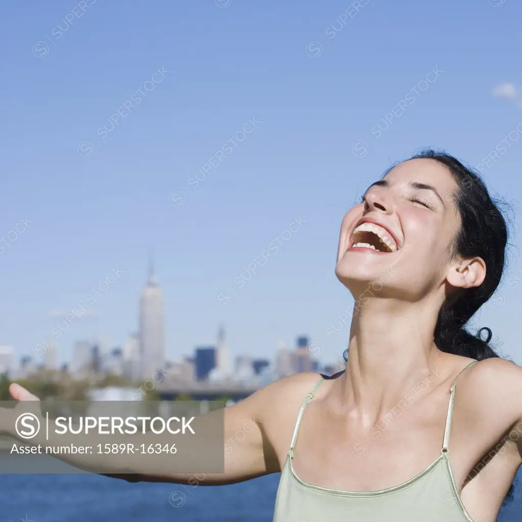 Young woman laughing with outstretched arms