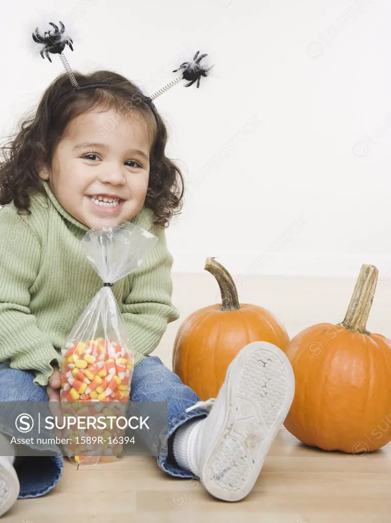 Portrait of little girl with pumpkins and candy corn