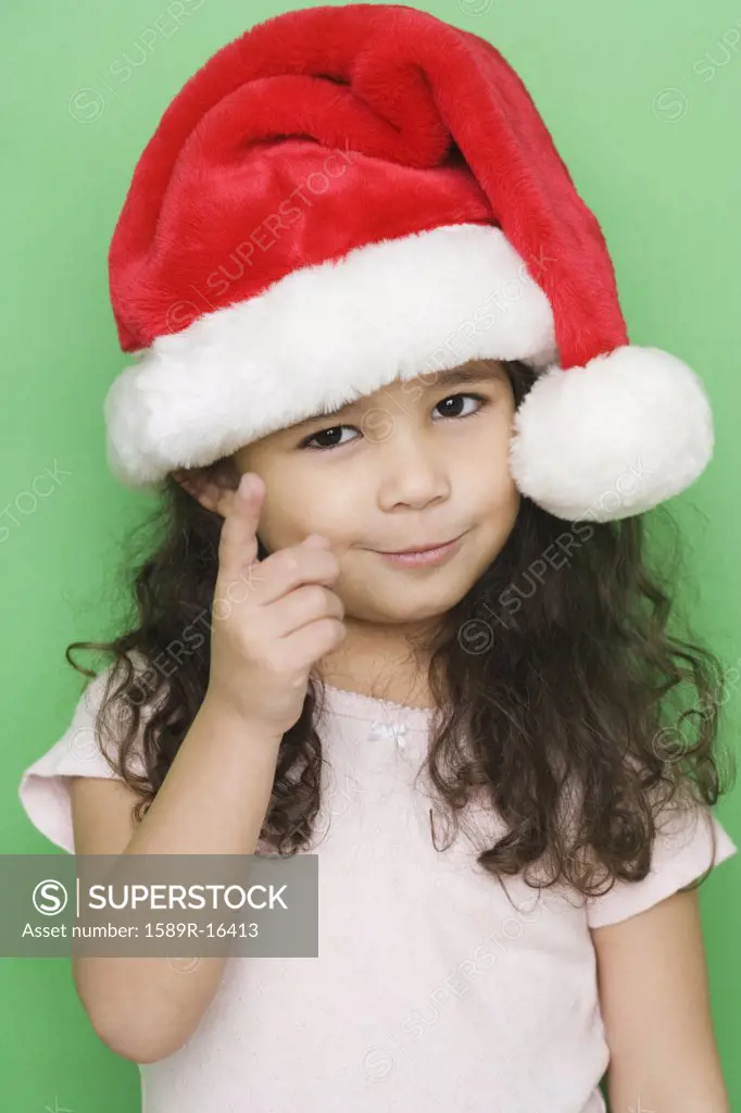 Portrait of girl wearing santa hat and pointing