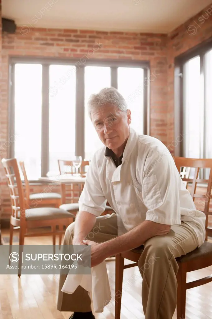 Caucasian chef sitting in restaurant