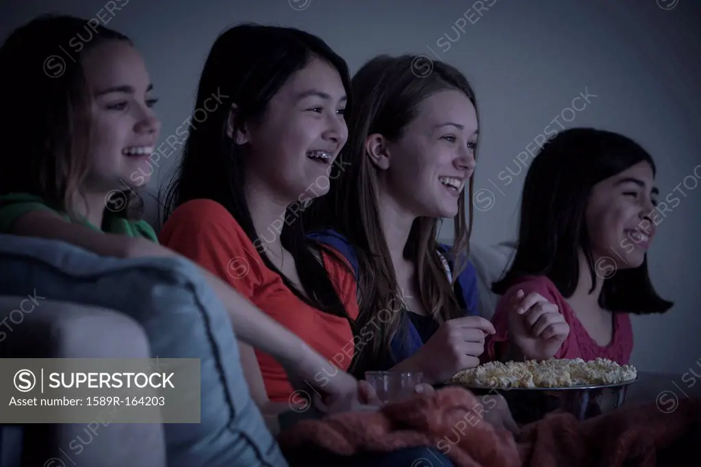 Friends eating popcorn and watching a movie