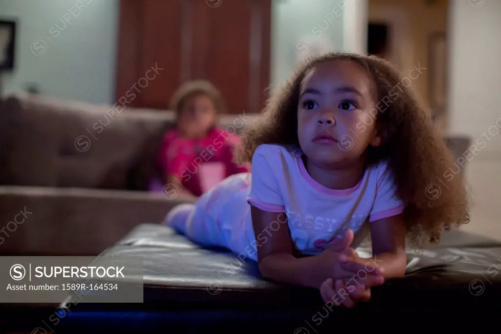 Mixed race girls watching television