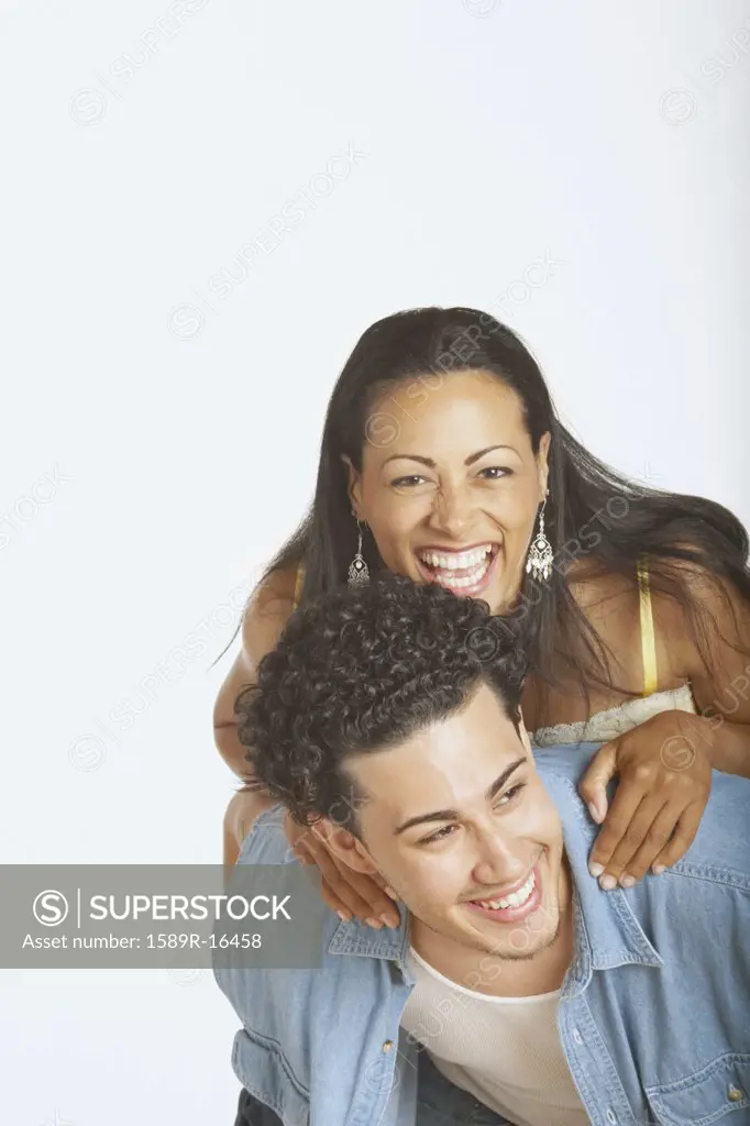 Young man carrying his girlfriend on his back