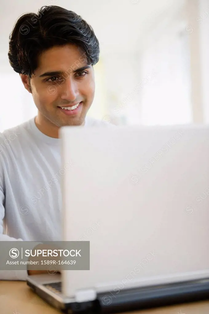 Mixed race man using laptop