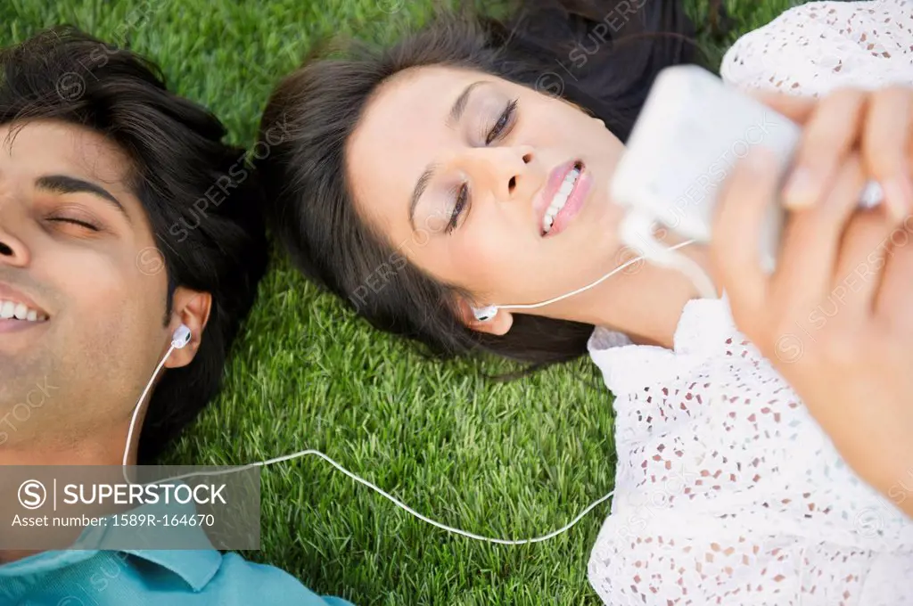 Mixed race couple listening to mp3 player together