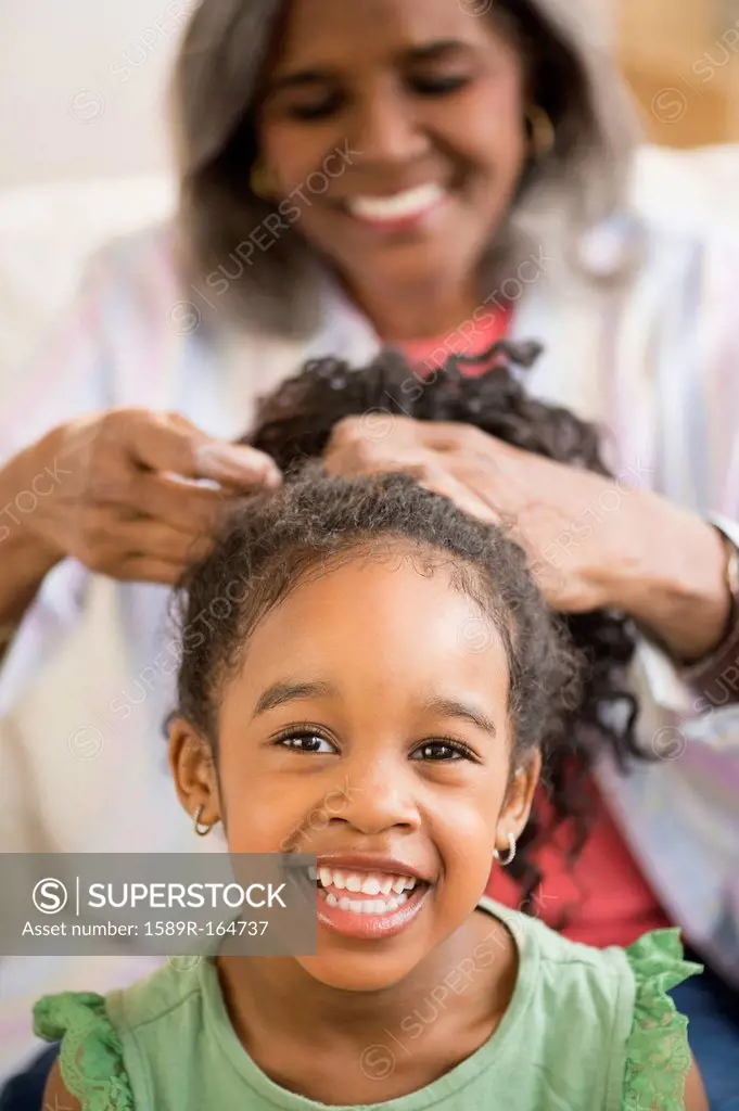 African American woman fixing granddaughter´s hair