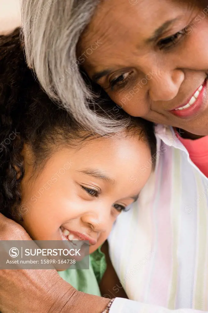 African American grandmother and granddaughter hugging