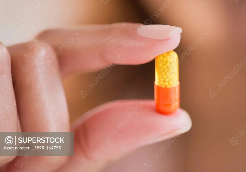 Cape Verdean woman holding pill capsule