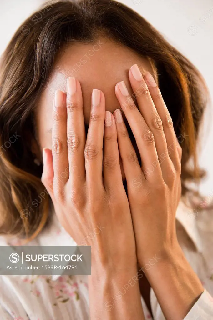 Cape Verdean woman with hands over face