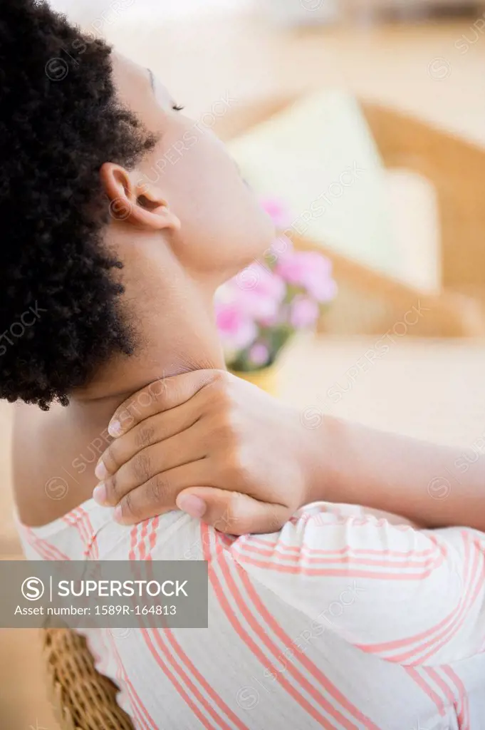 African American woman rubbing sore neck