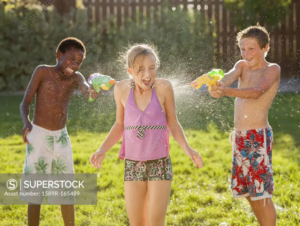 Boys squirting girl with water guns