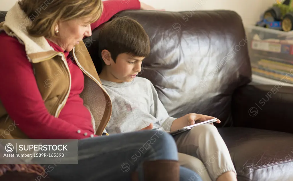 Hispanic mother and son using digital tablet