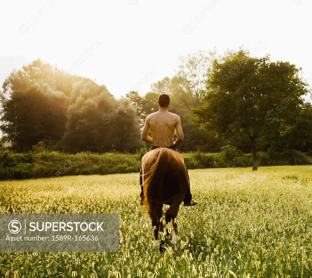 Caucasian man riding horse in field