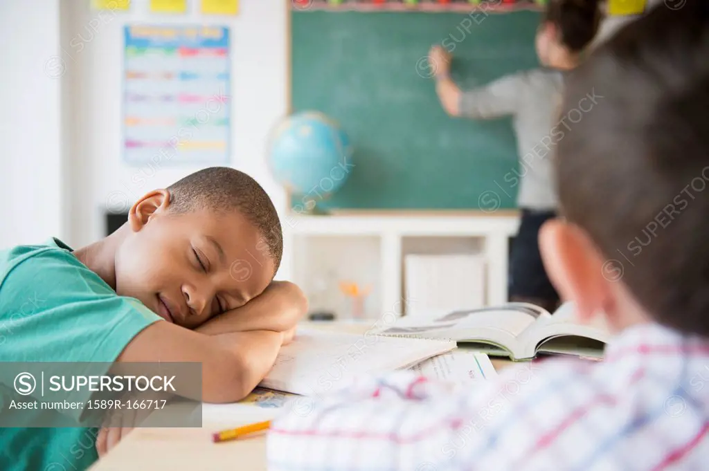 African American boy sleeping in classroom