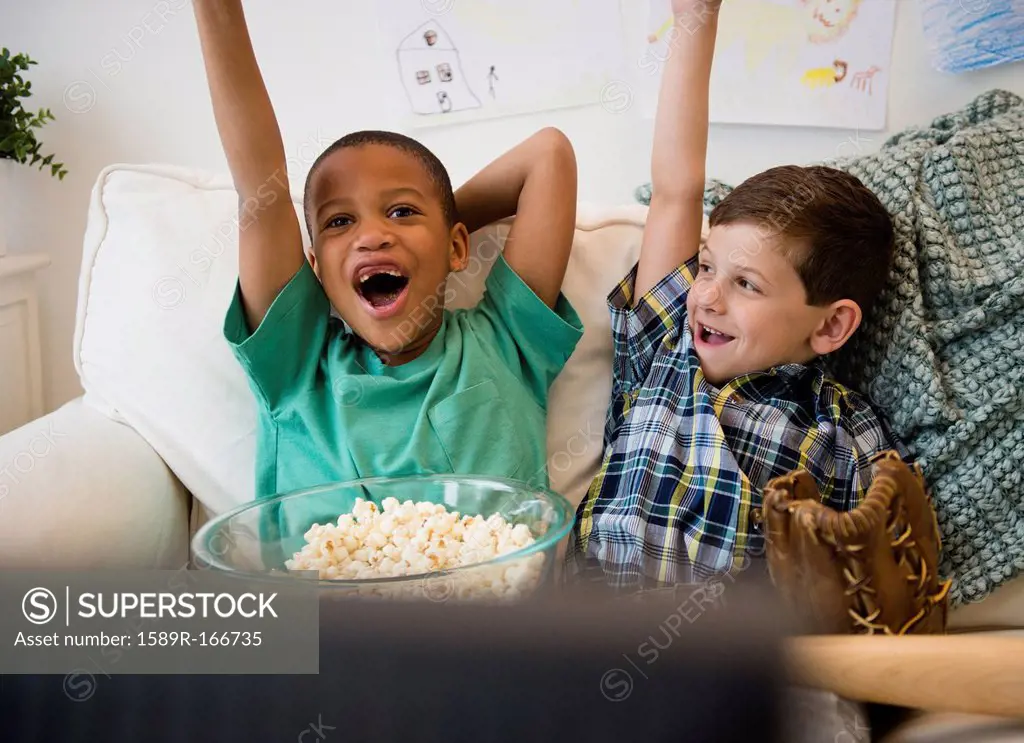 Boys eating popcorn and cheering