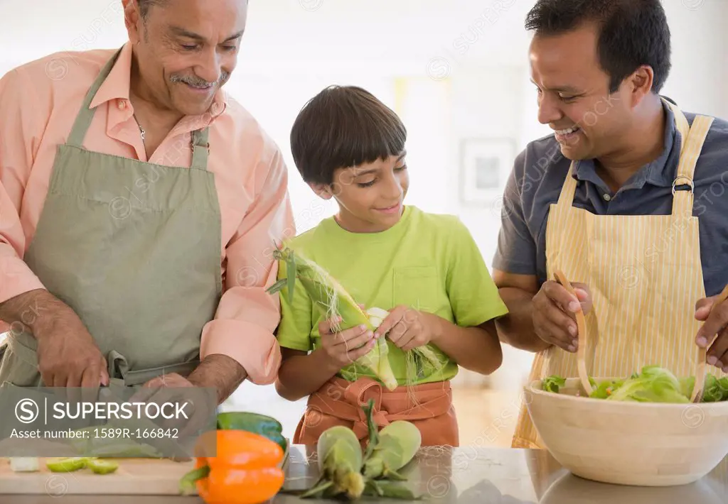 Hispanic grandfather, father and son preparing food