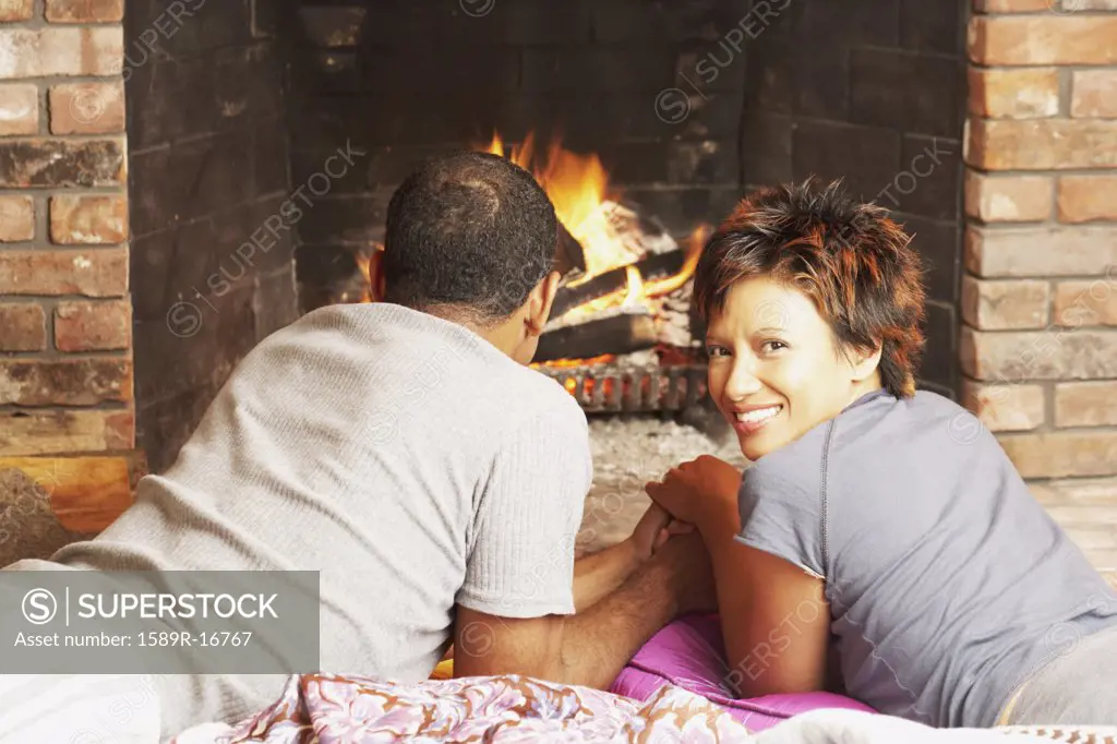 Young couple relaxing in front of a fire