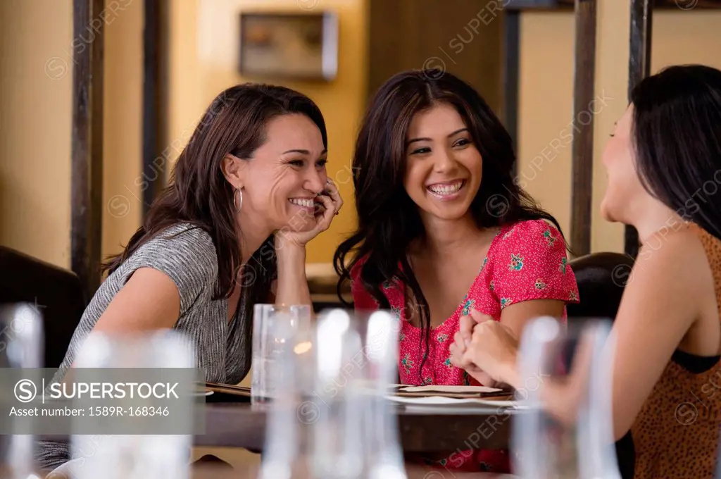 Hispanic friends having dinner in restaurant