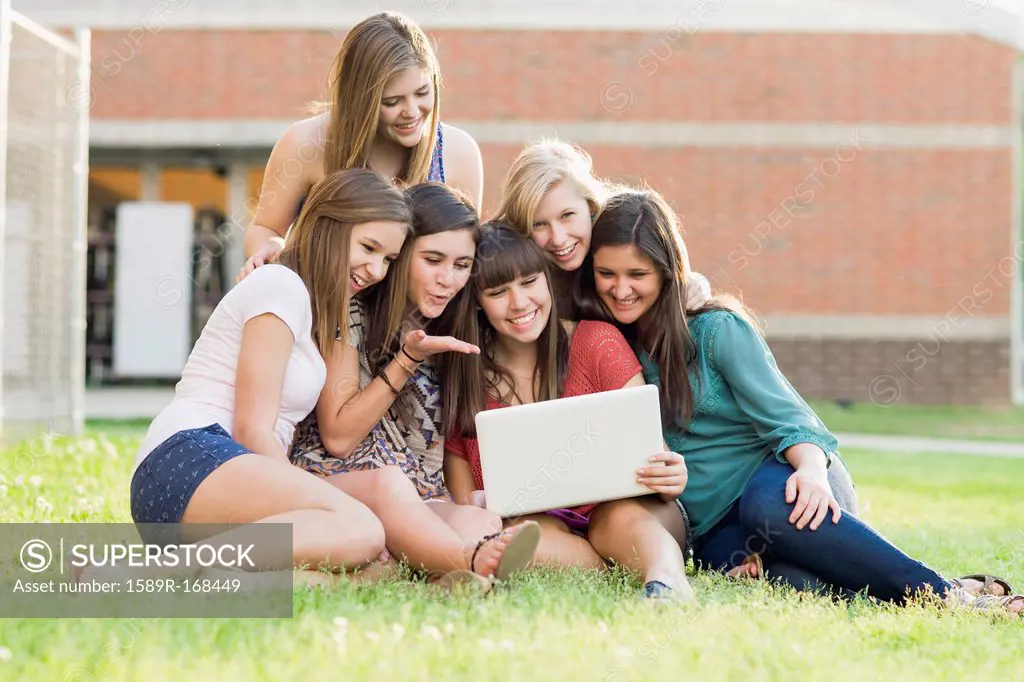 Caucasian friends looking at laptop together