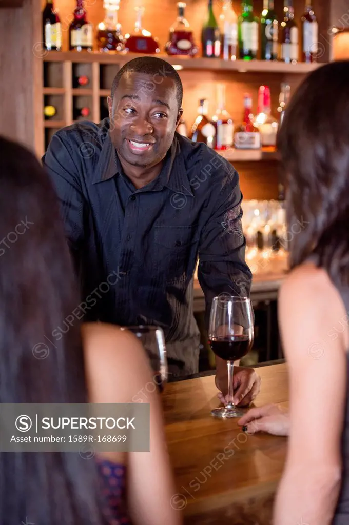 African American bartender serving customers
