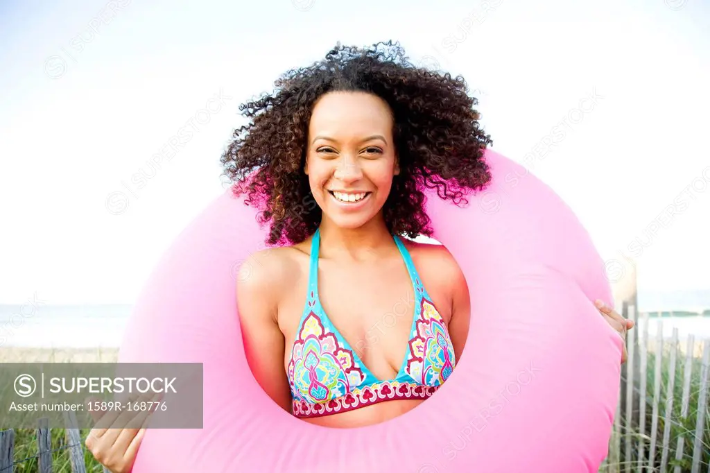 Smiling Hispanic woman holding inflatable ring