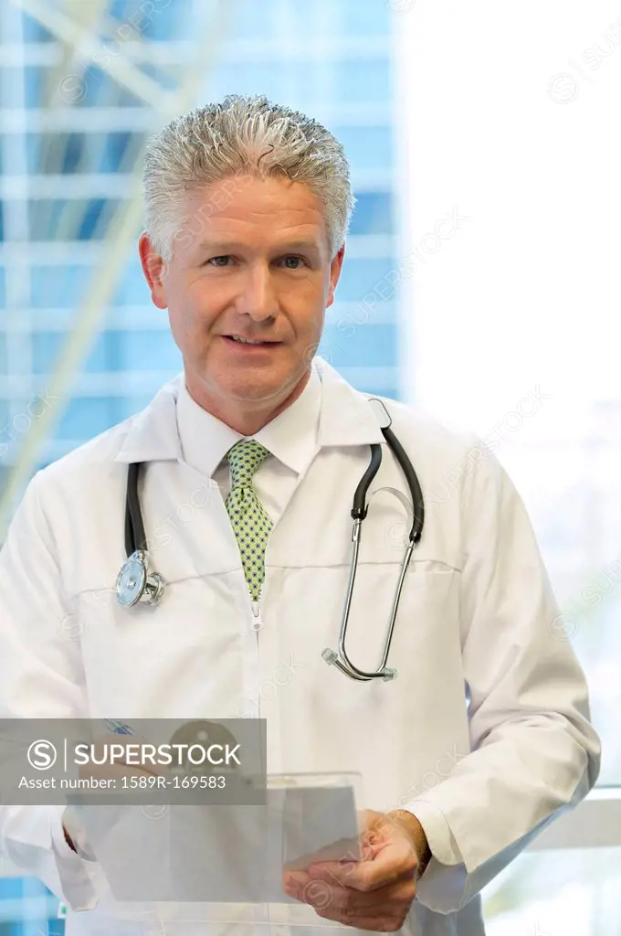 Caucasian doctor holding clipboard