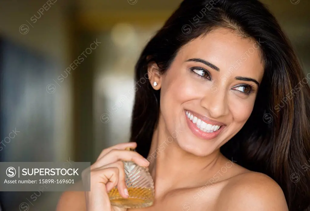 Indian woman spraying perfume on neck