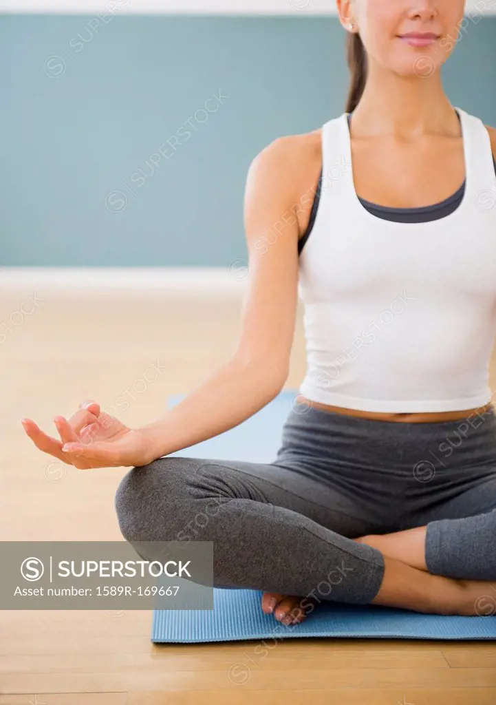 Caucasian woman meditating on exercise mat