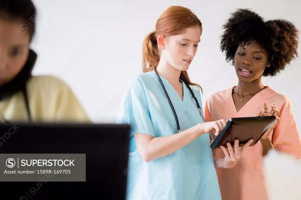 Nurses using tablet computer in hospital