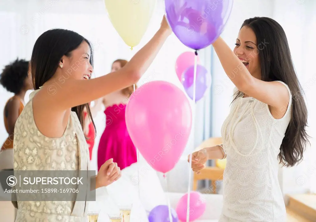 Women playing with balloons at party