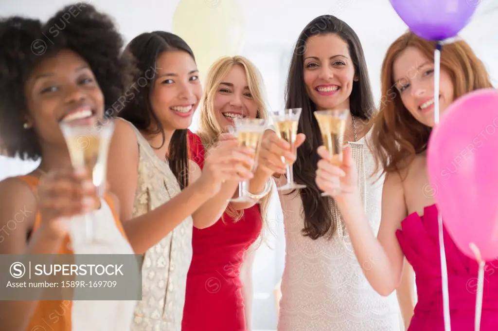 Women toasting each other with champagne at party