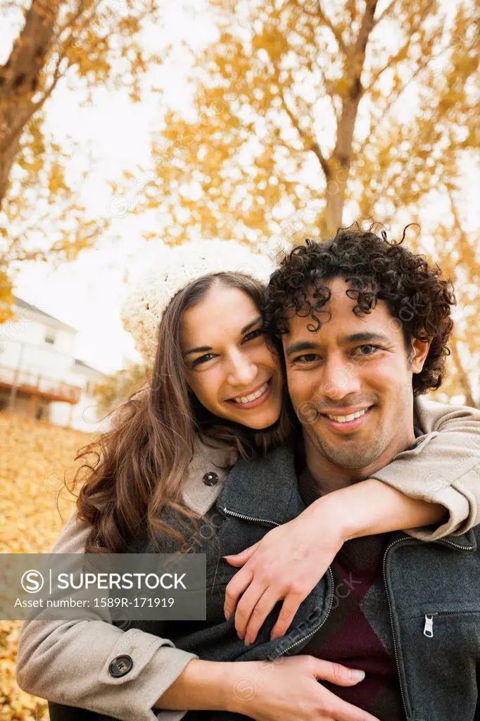 Couple hugging in autumn leaves