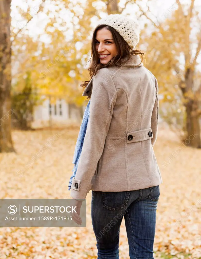 Caucasian woman walking in autumn leaves