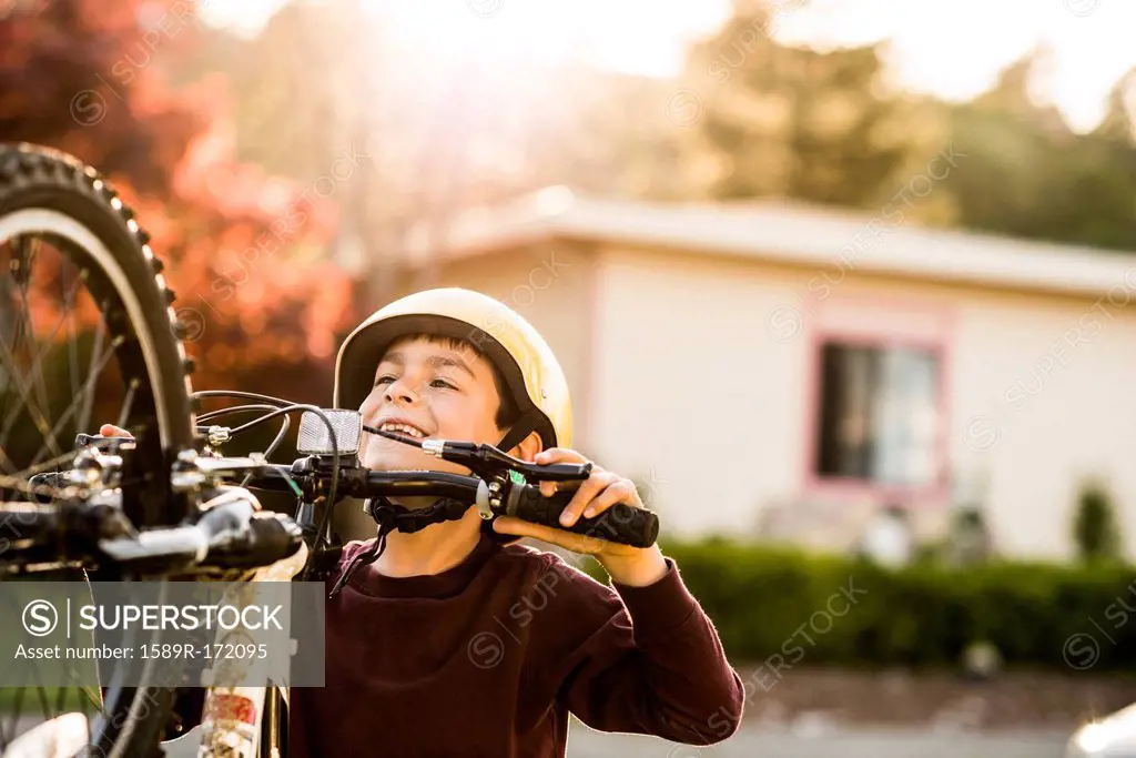 Mixed race boy playing with mountain bike