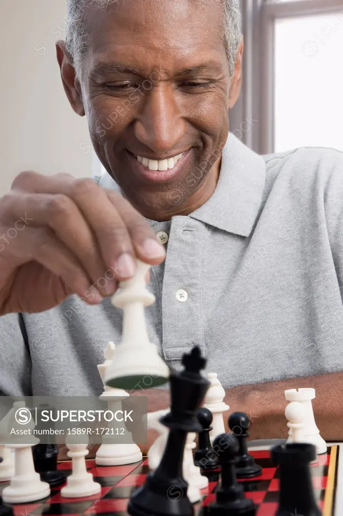 Smiling mixed race man playing chess