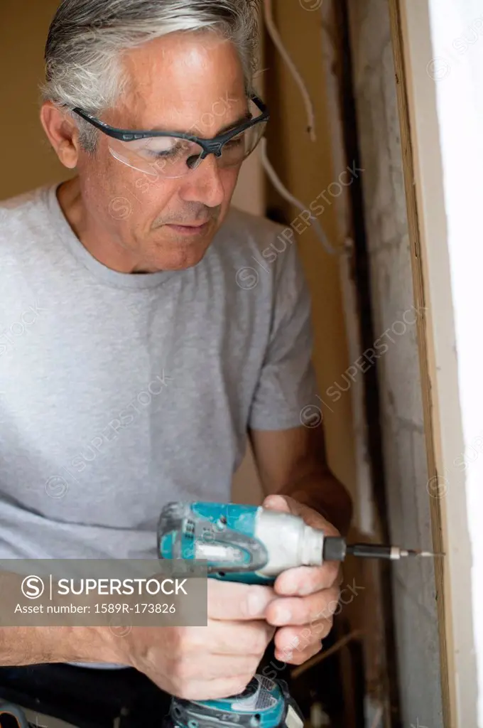 Caucasian man using power drill