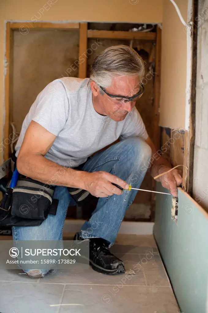 Caucasian man using screwdriver