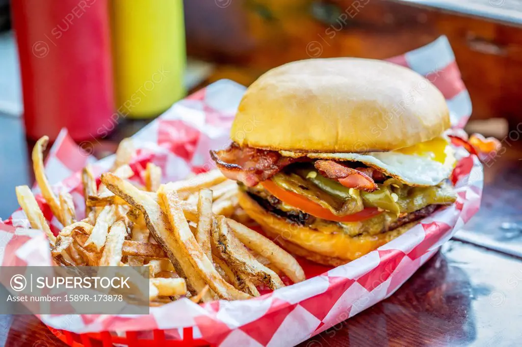 Basket of french fries with cheeseburger and egg