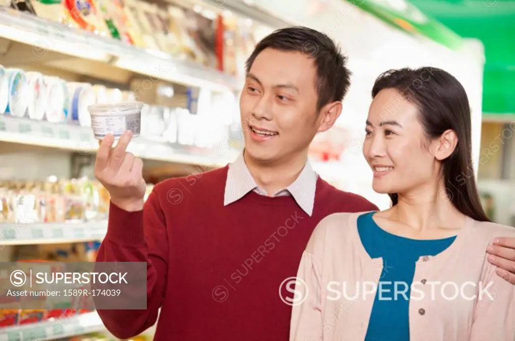 Chinese couple looking at package in grocery store