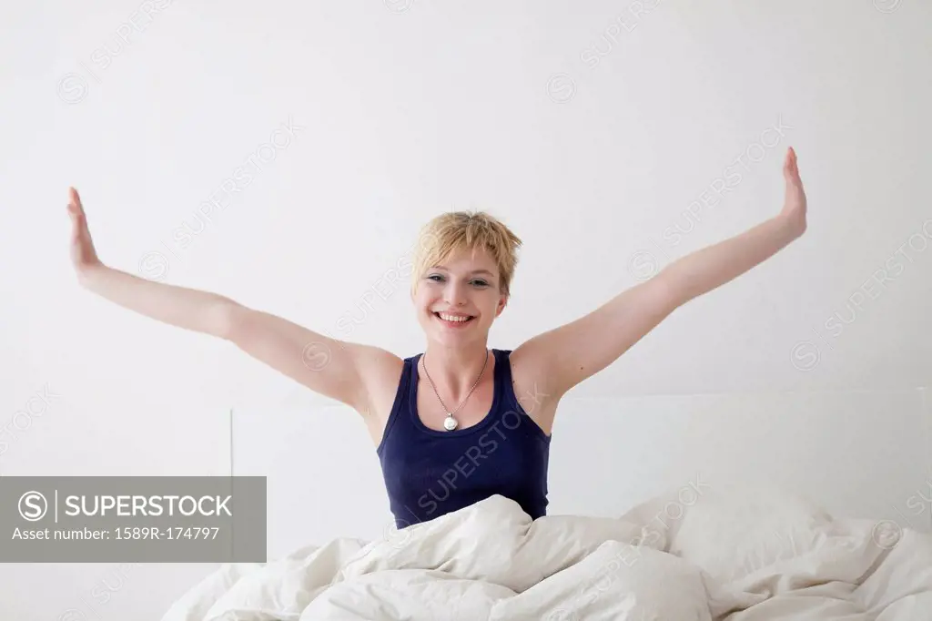 Caucasian woman stretching on bed