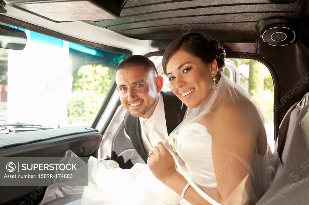 Hispanic bride and groom in truck
