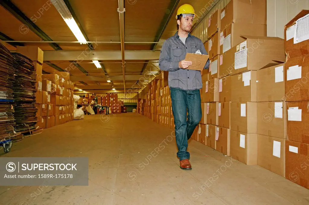 Caucasian worker checking product in warehouse