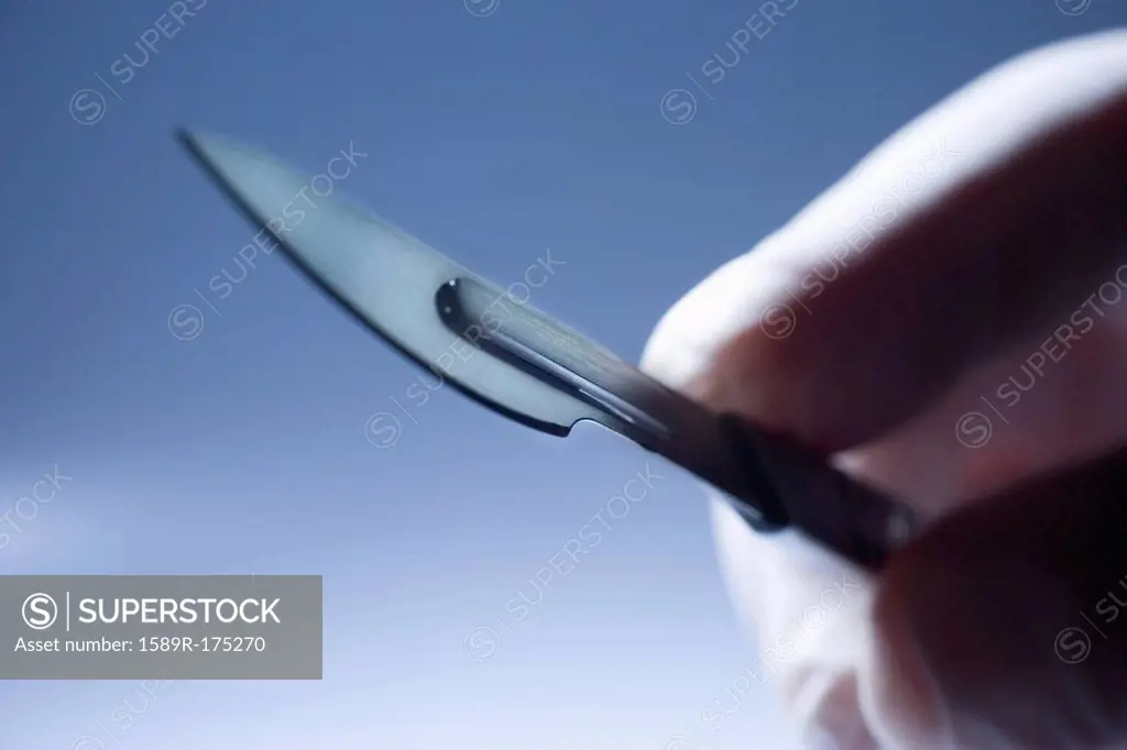Close up of Hispanic doctor holding surgical equipment
