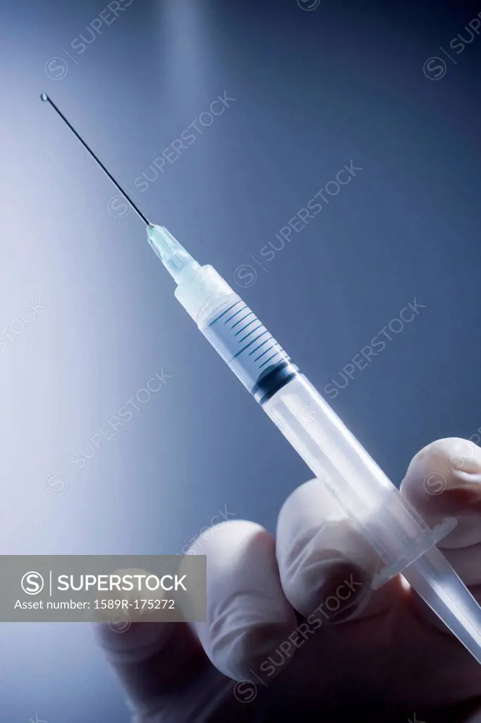 Close up of Hispanic doctor holding syringe