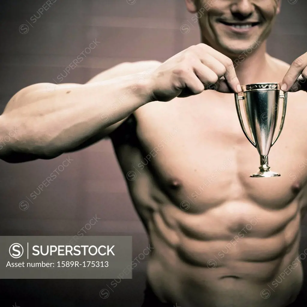 Caucasian man holding small trophy
