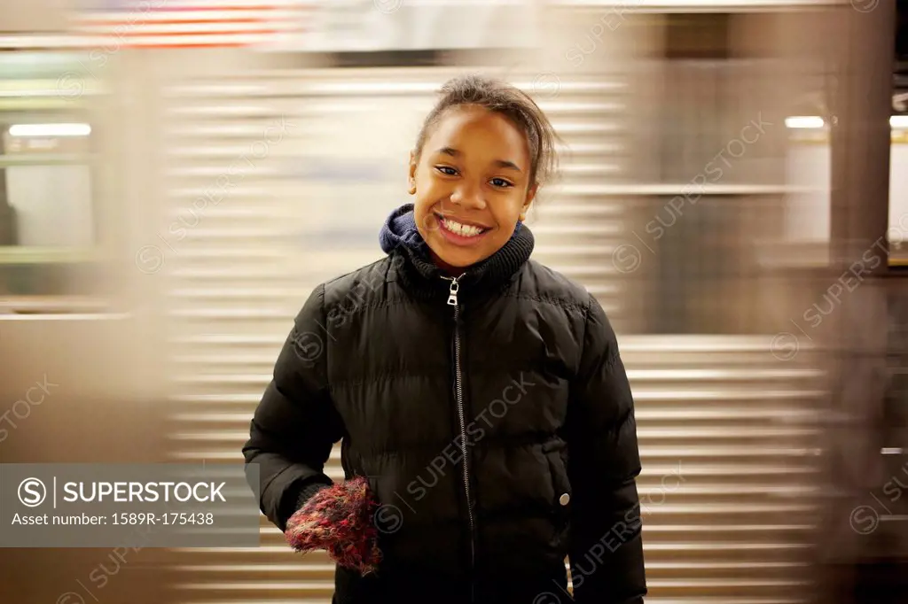 Mixed race girl smiling in subway station