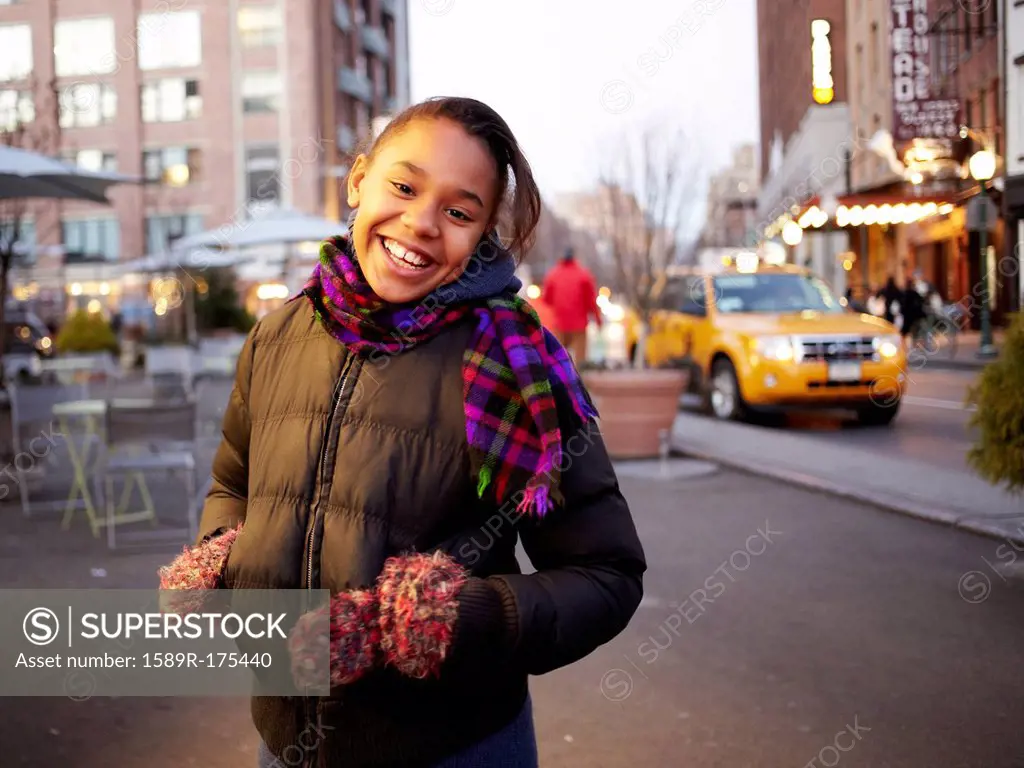 Mixed race girl smiling on city street, New York, New York, United States