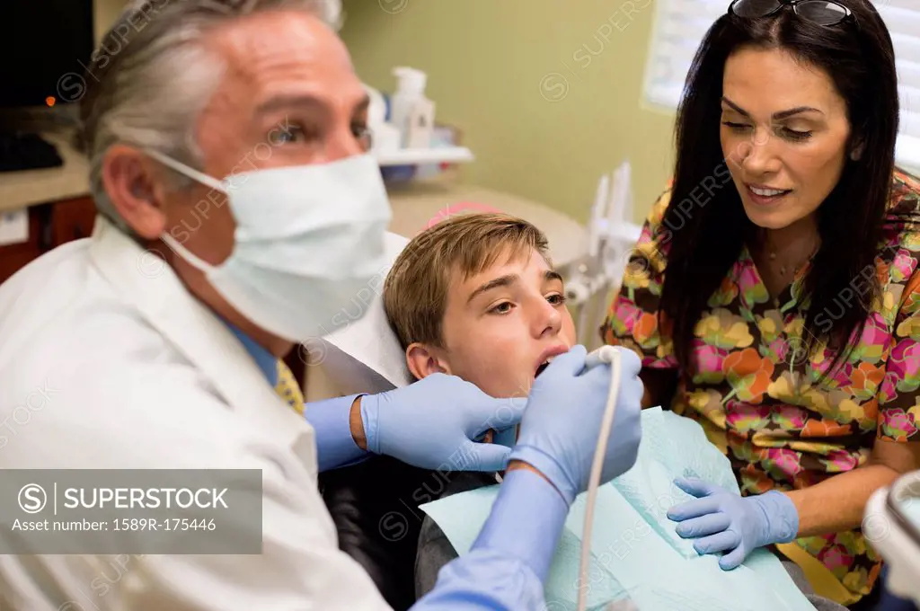 Dentist and nurse examining patient's mouth