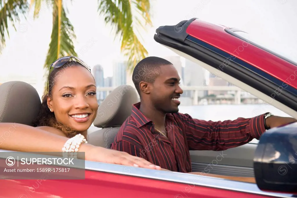African American couple driving in convertible