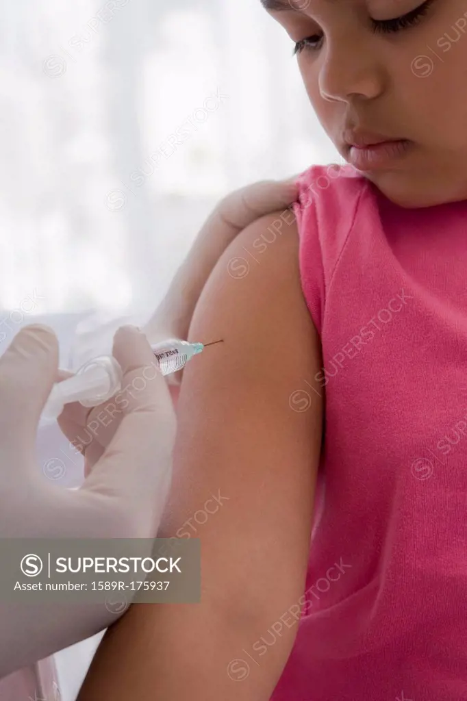 Hispanic doctor giving patient injection in arm
